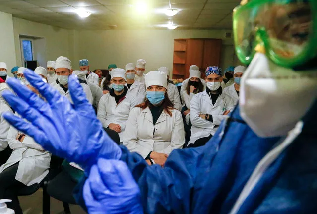 A doctor demonstrates how to use protective gear to young medical workers during the study process about the reanimation of COVID-19 patients, in the lecture hall of Vishnevscogo Hospital in the pro-Russian militants controlled city of Donetsk, Ukraine, 21 December 2020. Ukraine reported a sharp decrease in the number of new active COVID-19 cases that had been confirmed across the country on 21 December 2020, that is 6,545 against 8,325 registered a day earlier. In total, there have been 1,052,919 reports on suspected COVID-19 since the beginning of 2020. (Photo by Dave Mustaine/EPA/EFE)