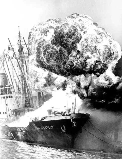 A ball of flames and smoke rises into the air above the German freighter “Moselstein” after a second explosion shook the vessel in Antwerp Harbor, Belgium on December 28, 1966. Flames reached a height of 150 feet, and because of the intense heat and danger of further explosions the fire brigade could only protect adjacent ships. (Photo by AP Photo)