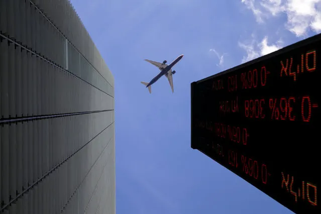 A plane flies above an electronic board displaying market data outiside the Tel Aviv Stock Exchange in Tel Aviv, Israel, January 29, 2017. (Photo by Baz Ratner/Reuters)