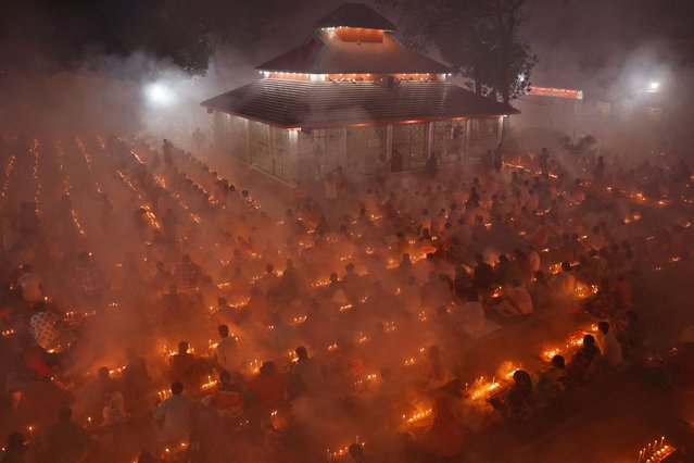 Hindu devotees sit together in front of oil lamps, and pray to Lokenath Brahmachari, a Hindu saint and philosopher, as they observe the Rakher Upobash festival, at a temple in Narayanganj, Bangladesh, on November 5, 2024. (Photo by Mohammad Ponir Hossain/Reuters)