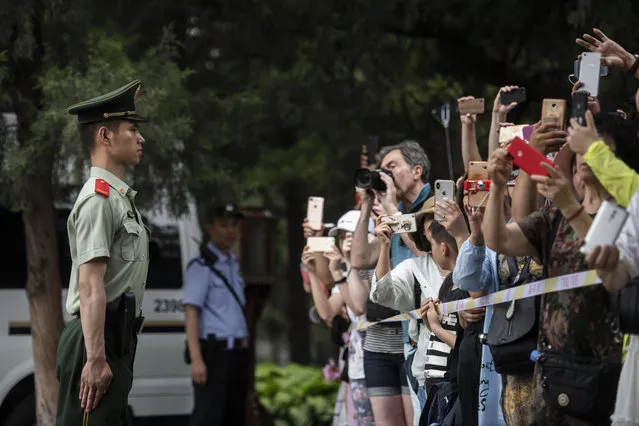 Chinese tourists take pictures of French Prime Minister Edouard Philippe during a private visit at the Temple of Heaven in Beijing Monday, June 25, 2018. (Photo by Fred Dufour/Pool Photo via AP Photo)