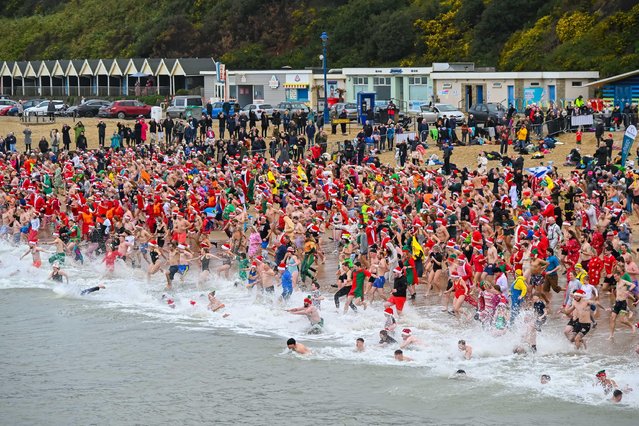 A thousand Christmas Day revellers wearing festive fancy dress take the plunge in to the cold sea at Boscombe at Bournemouth in Dorset, UK on December 25, 2024 for the Macmillan White Christmas Dip charity swim on an unseasonably warm morning. (Photo by Graham Hunt/Alamy Live News)
