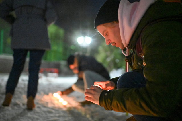 Supporters of Russian opposition politician Alexei Navalny, who was recently jailed for parole violations, light candles in a residential courtyard during a gathering on Valentine's Day in Omsk, Russia on February 14, 2021. (Photo by Alexey Malgavko/Reuters)