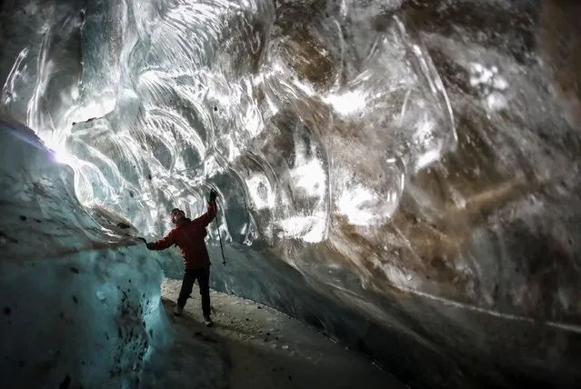 A tourist visits the Oktyabrskaya cave of the Bogdanovich glacier located in the Tian Shan mountain range near Almaty, Kazakhstan on February 20, 2021. (Photo by Pavel Mikheyev/Reuters)