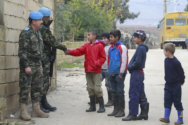 Boys greet members of U.N. peacekeepers of the United Nations Interim Force in Lebanon (UNIFIL) in the town of Al Wazzani, near the Lebanese-Israeli border, in southern Lebanon January 5, 2016. (Photo by Aziz Taher/Reuters)