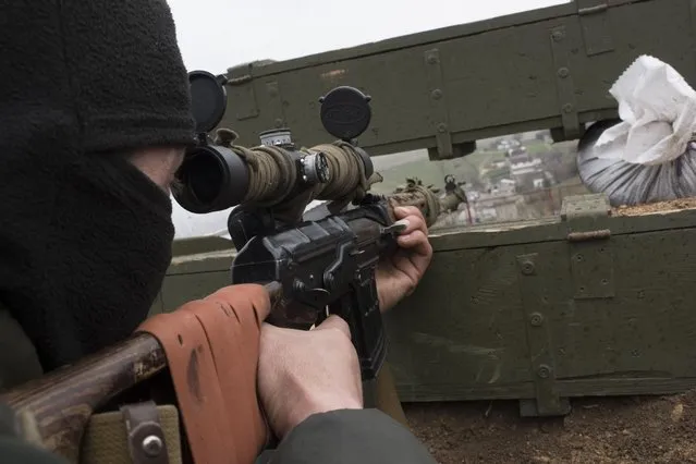 A Ukrainian serviceman guards positions in the village of Berdyanske near Shyrokyne, eastern Ukraine, Tuesday, April 14, 2015. Shyrokyne, a village on the Azov Sea that has been the epicenter of recent fighting, has changed hands repeatedly throughout the conflict.  (AP Photo/Evgeniy Maloletka)