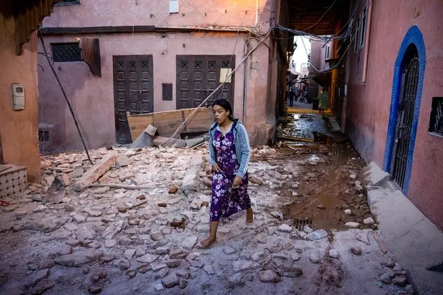 A woman walks through the rubbles past earthquake-damaged houses in the old city in Marrakesh on September 9, 2023. (Photo by Fadel Senna/AFP Photo)