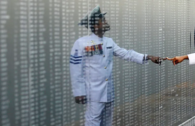 A Navy officer looks at the heroes' name board of a war memorial, during a commemoration ceremony to mark the 9th anniversary of the fallen soldiers during the final stage of war between Tamil Tigers and government army, in Colombo, Sri Lanka May 19, 2018. (Photo by Dinuka Liyanawatte/Reuters)