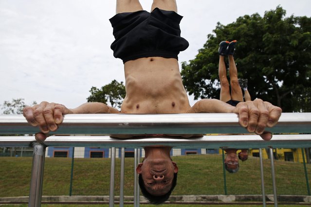 Ng Bee Kia (L-R), 70, Ngai Hin Kwok, 66, and Ng Siu Chi, 57, who form Team Strong Silvers, a team of senior citizens who train in calisthenics, work out at a stadium in Singapore March 15, 2015. (Photo by Edgar Su/Reuters)