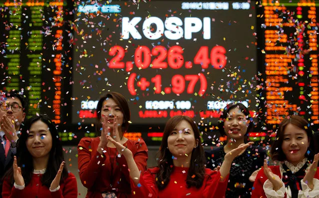Employees of the Korea Exchange (KRX) pose in front of the final stock price index during a photo opportunity for the media at the ceremonial closing event of the 2016 stock market in Seoul, South Korea, December 29, 2016. (Photo by Kim Hong-Ji/Reuters)