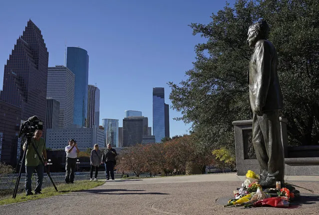 Visitors look at a statue of former President George H.W. Bush stands in downtown Houston, Sunday, December 2, 2018. Bush has died at age 94. Bush is returning to Washington as a revered political statesman, hailed by leaders across the political spectrum and around the world as a man not only of greatness but also of uncommon decency and kindness.  Bush, died late Friday at his Houston home at age 94, is to be honored with a state funeral at National Cathedral in the nation's capital on Wednesday, followed by burial Thursday on the grounds of his presidential library at Texas A&M. (Photo by David J. Phillip/AP Photo)