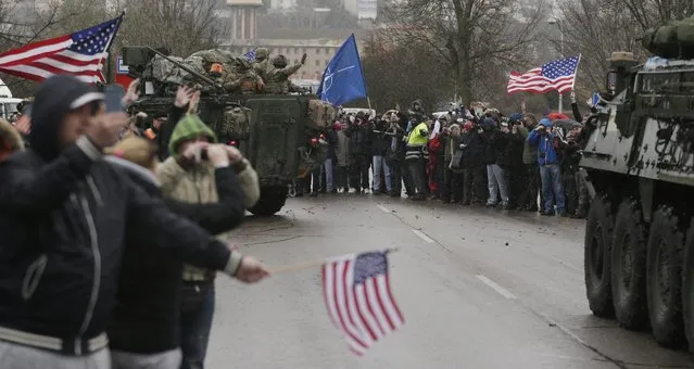 US army soldiers wave to their supporters as they arrive with their convoy in Prague, Czech Republic, Monday, March 30, 2015. (Photo by Petr David Josek/AP Photo)
