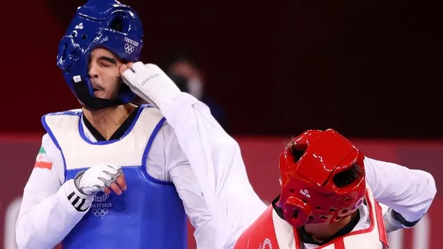 Mirhashem Hosseini (L) of Team Iran competes against Ulugbek Rashitov of Team Uzbekistan during the Men's -68kg Taekwondo Quarterfinal contest on day two of the Tokyo 2020 Olympic Games at Makuhari Messe Hall on July 25, 2021 in Chiba, Japan. (Photo by Murad Sezer/Reuters)