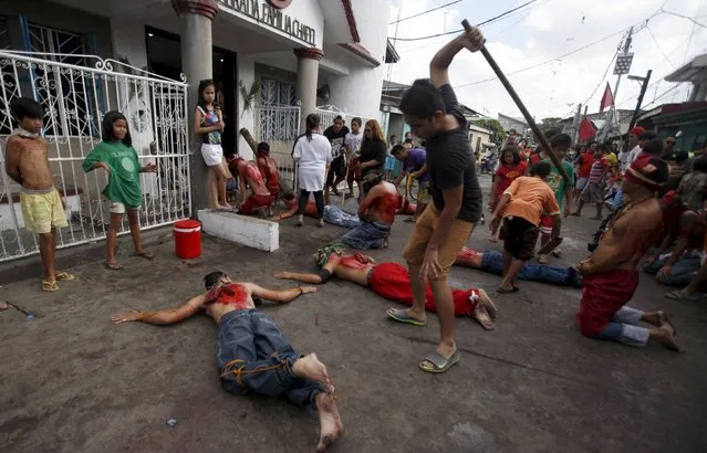 A man uses a stick to whip a penitent in front of a chapel during a Holy Week ritual in Angeles city, Pampanga in northern Philippines April 2, 2015. Flagellation is a form of religious discipline observed every lenten season by Catholic devotees in the Philippines. (Photo by Lorgina Minguito/Reuters)
