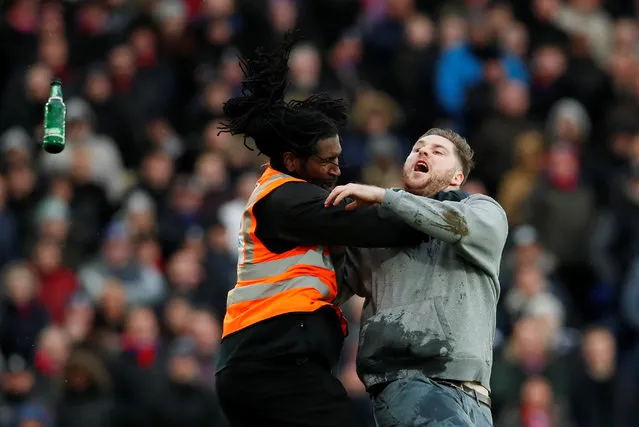 A steward apprehends a pitch invader as Crystal Palace plays Newcastle United in London, February 4, 2018. (Photo by David Klein/Reuters)