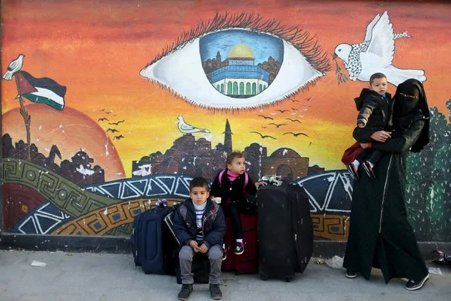 Members of a Palestinian family gather in front of a mural as they wait for a travel permit to cross into Egypt through the Rafah border crossing between Egypt and the southern Gaza Strip February 14, 2016. Egypt opened the Rafah border crossing on Saturday for two days to allow Palestinians on humanitarian grounds to travel in and out of the Gaza Strip, officials said. Gaza, a small impoverished coastal enclave, is under blockade by neighbouring Israel, and Egypt has kept its Rafah crossing largely shut since Cairo's Islamist president was toppled by the army in 2013. (Photo by Ibraheem Abu Mustafa/Reuters)