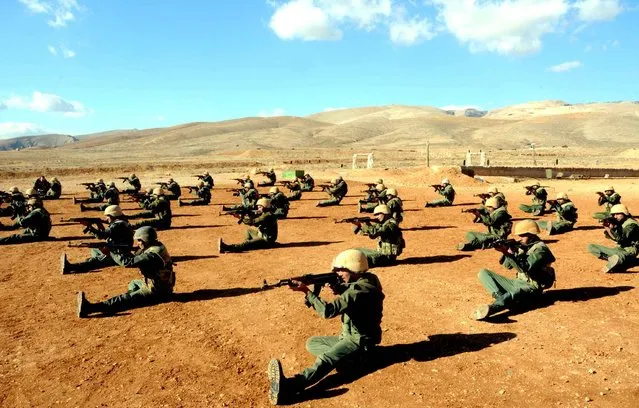 A handout picture released by the official Syrian Arab News Agency (SANA) on December 9, 2013 shows pro-regime forces taking part in a military training exercise at an undisclosed location in Syria. Syrian regime troops have regained control of the key Damascus-Homs highway after seizing most of the town of Nabak in the Qalamoun region, a monitoring group said. (Photo by AFP Photo/HO/SANA)