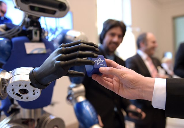 Humanoid robot “Toro” at the German Centre for Aeronautics (DLR) receives a cube, at the Future Perspective Industry 2030 (Zukunftsperspektive Industrie 2030) conference of the Federal Ministry of Economics in Berlin, Germany, 18 February 2016. (Photo by Rainer Jensen/EPA)