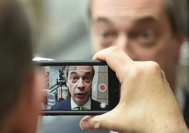 A man films Nigel Farage, the UKIP leader, as he speaks during an interview at an EU summit in Brussels on Friday, February 19, 2016. European Union leaders are holding a summit in Brussels on Thursday and Friday to hammer out a deal designed to keep Britain in the 28-nation bloc. (Photo by Geert Vanden Wijngaert/AP Photo)