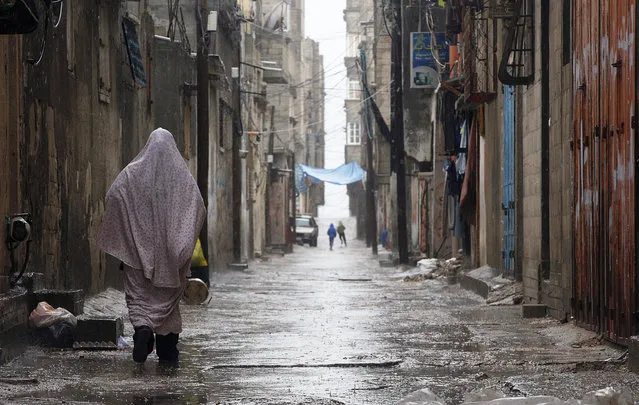 A Palestinian woman walks in the street during heavy rain in Al Shatea in the west of Gaza City, April 12, 2015. (Photo by Mohammed Saber/EPA)