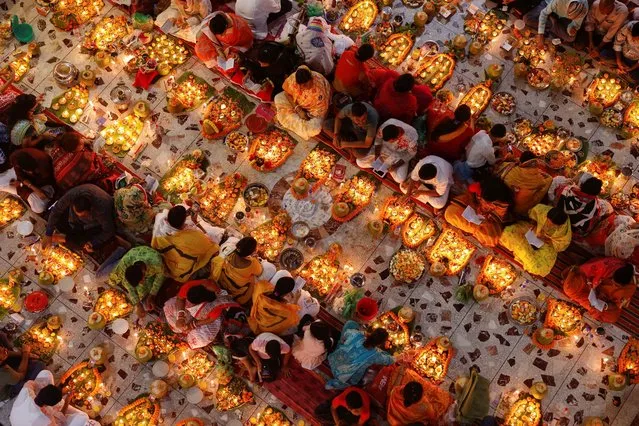 Hindu devotees sit together on the floor of a temple while praying to Lokenath Brahmachari, a Hindu saint, as they observe Rakher Upabash, in Dhaka, Bangladesh on November 14, 2023. (Photo by Mohammad Ponir Hossain/Reuters)
