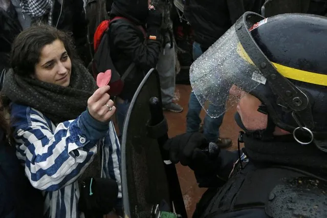 A student offers a heart-shaped paper cutout to a French CRS riot policeman during a demonstration against the French labour law proposal in Lyon, France, as part of nationwide labor reform bill protests by students and union members, March 9, 2016. (Photo by Robert Pratta/Reuters)