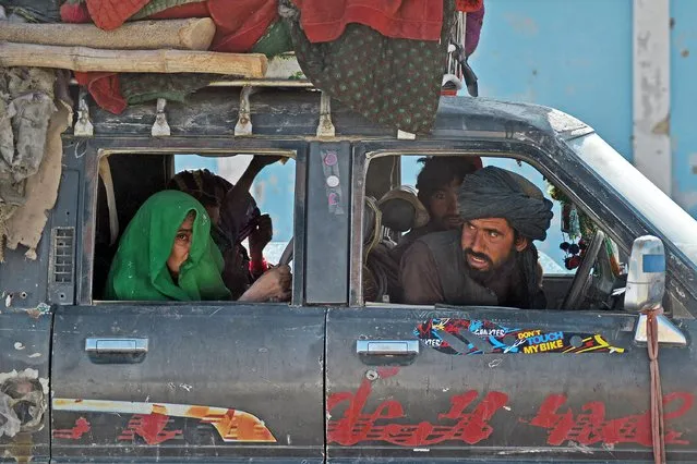 In this picture taken on October 14, 2021, Afghans travel in a vehicle at Babro village in Arghandab district. (Photo by Javed Tanveer/AFP Photo)