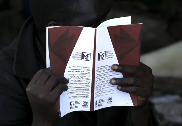 A Sudanese immigrant reads a pamphlet distributed by the UNHCR on racism in the western Greek town of Patras May 4, 2015. (Photo by Yannis Behrakis/Reuters)