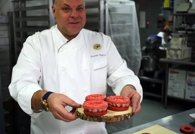 French pastry chef François Payard makes macaronuts, a fusion between macaron and doughnut, at his bakery in New York on March 17, 2016. The confection is about the size of the palm of your hand. The bottom is a strawberry-flavored dough base, with strawberry cream filling and topped with a macaron shell. Francois Payard will be debuting this $5 confection at their five city locations on Sunday, March 20 to commemorate Macaron Day. (Photo by Jewel Samad/AFP Photo)