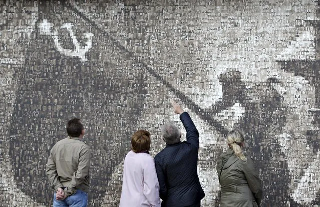 People look at photos on the “We have won!” memorial panel in Stavropol, Russia May 5, 2015. The panel shows the famous Soviet picture “Flag above the Reichstag” made from 4,222 portraits of defenders of their Motherland during the World War II from Stavropol, local media reported. (Photo by Eduard Korniyenko/Reuters)