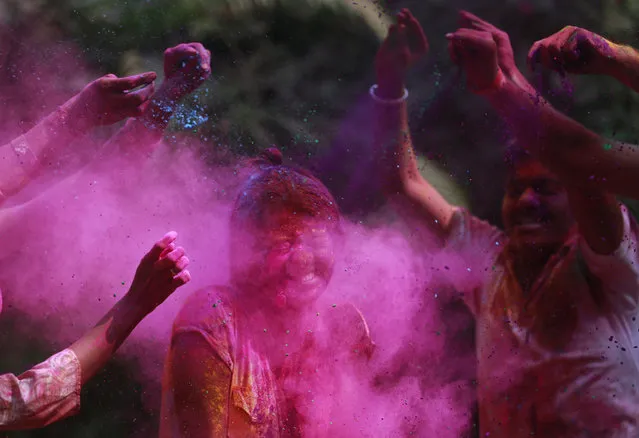 People smear colored powder on the face of a girl during celebrations marking Holi, the Hindu festival of colors, in Mumbai India, Thursday, March 24, 2016. The festival heralds the arrival of spring. (Photo by Rafiq Maqbool/AP Photo)