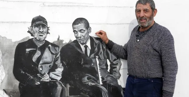 Ivan, a resident of the Staro Zhelezare village, poses in front of a mural depicting his own portrait sitting next to the U.S. President Barak Obama on January 27, 2016 in Bulgaria. (Photo by Valentina Petrova/AP Photo)