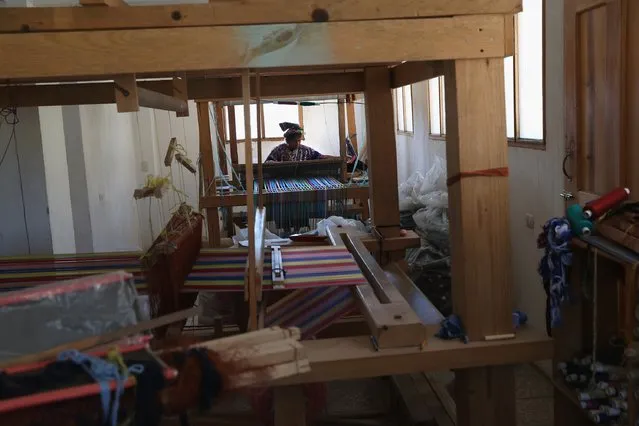 Indigenous Mayan weaver Delfina Perez, who's husband has worked in the U.S. as an immigrant for 20 years, works on a foot loom at the Grupo Cajola weaving cooperative on February 11, 2017 in Cajola, Guatemala. Women are especially effected by emigration from Guatemala, where some 70 percent of the men have left to work as undocumented immigrants in the United States, many of them leaving behind wives and children who only know their fathers online, if at all. (Photo by John Moore/Getty Images)