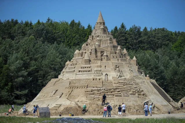 Sculptors are working on the sculpture “Largest Sandcastle in the World” at the Sand Sculpture Festival in Binz on the island of Ruegen, Germany, Tuesday, June 5, 2019. The team wants to use more than 11,000 tons of pressed sand for the giant work of art with a planned height of 17.5 meters. (Photo by Jens Buettner/dpa via AP Photo)