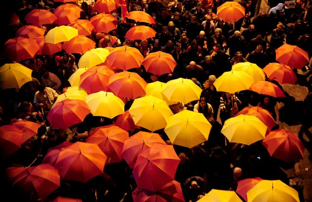 Protesters shout slogans while holding red and yellow umbrellas during demonstrations against an agreement that would ensure the wider official use of the Albanian language, in Skopje, Macedonia, March 1, 2017. (Photo by Reuters/Stringer)