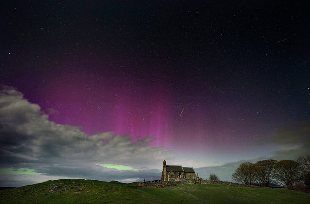 The aurora borealis, also known as the Northern Lights, illuminate the sky just before midnight over St Aidan's church in Thockrington, Northumberland, UK on Wednesday, April 17, 2024. (Photo by Owen Humphreys/PA Images via Getty Images)