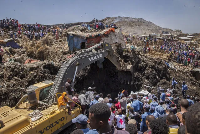 In this Sunday, March 12, 2017 photo, rescuers work at the scene of a garbage landslide, on the outskirts of the capital Addis Ababa, in Ethiopia. (Photo by Mulugeta Ayene/AP Photo)
