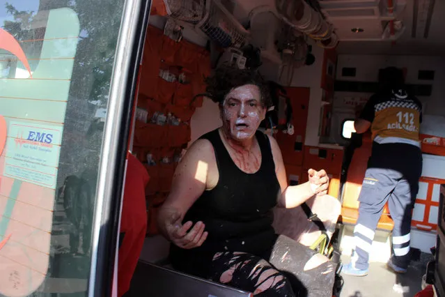 An injured person sits in an ambulance after a suicide bomb attack outside the historical tourist destination at Ulu Cami in Bursa, Turkey, Wednesday, April 27, 2016.  The office of the governor of Bursa said in a statement carried by the state-owned Anadolu Agency that a woman believed to be a suicide bomber blew herself up. (Photo by IHA Agency via AP Photo)