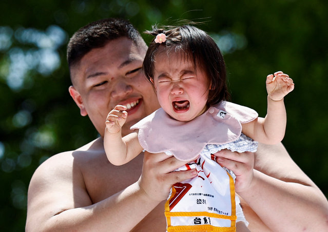 A baby cries while held up by an amateur sumo wrestler during “Nakizumo” or a baby-crying sumo contest at Sensoji temple in Tokyo, Japan, on April 28, 2024. (Photo by Issei Kato/Reuters)