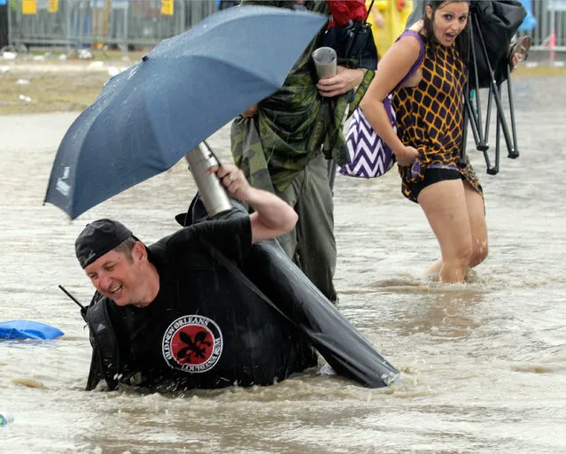 The Acura Stage area is flooded after a storm dumped several inches of rain on the second Saturday of the New Orleans Jazz Fest at the Fair Grounds, Saturday, April 30, 2016. (Photo by David Grunfeld/NOLA.com/The Times-Picayune via AP Photo)