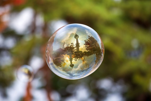 This photo taken on October 23, 2022 shows a soap bubble reflecting the Namsan Seoul Tower at Namsan Park in Seoul, South Korea. (Photo by Xinhua News Agency/Rex Features/Shutterstock)