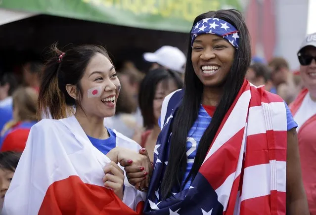 Risa Suzuki, left, of Japan, and Kerrry Haughton, of New York, smile after posing for photographers outside BC Place stadium before the FIFA Women's World Cup soccer championship between the United States and Japan later in the day, in Vancouver, British Columbia, Canada, Sunday, July 5, 2015. (Photo by Elaine Thompson/AP Photo)