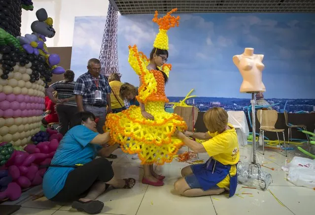 Designers make a final touch on an outfit made with air balloons during an international festival of air balloons design in Almaty, Kazakhstan, July 9, 2015. (Photo by Shamil Zhumatov/Reuters)