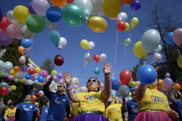 Young people with Down syndrome release colourful balloons during celebrations marking World Down Syndrome Day in Bucharest, Romania, Monday, March 21, 2022. Spirits were sky high on World Down Syndrome Day as up to 100 kids, teenagers and adults with the syndrome gathered to celebrate the event in the courtyard of a venue in the Romanian capital Bucharest. (Photo by Andreea Alexandru/AP Photo)
