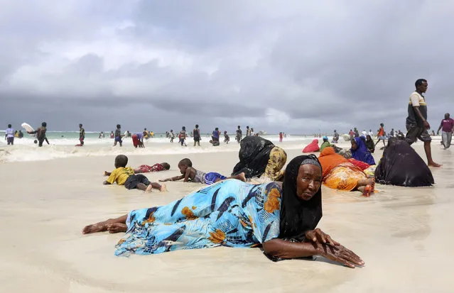 Women and children lie on the sand at Lido beach, north of Somalia's capital Mogadishu May 23, 2014. Lido beach was a famous attraction before Somalia tumbled into chaos in 1991 with the ousting of dictator Mohamed Siad Barre. In the last few years, the beach was a frontline for the Islamist al Shabaab militants, who later withdrew from most parts of Mogadishu. (Photo by Feisal Omar/Reuters)