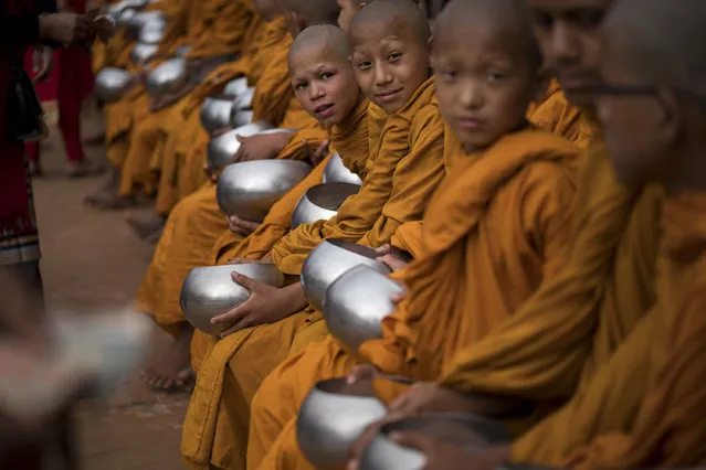 Young Buddhist monks receive donations during Buddha's birthday prayers at Boudha Stupa on May 10, 2017 in Kathmandu, Nepal. Vesak is observed during the full moon in May or June, which celebrates the stages of the life of Buddhism's founder, Gautama Buddha, from the birth, the enlightenment to nirvana, and his passing (Parinirvana). (Photo by Tom Van Cakenberghe/Getty Images)