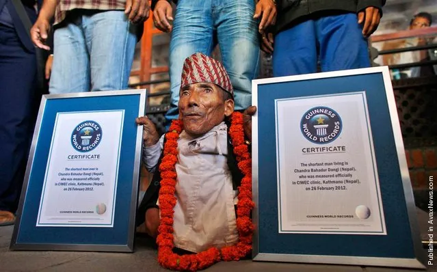Nepal's Chandra Bahadur Dangi poses with his certificates after being declared the world's shortest living man and shortest man ever by the Guinness Book of Records at a ceremony in Katmandu, Nepal, on Feb. 26, 2012. The 72-year-old man was measured at just 21.5 (54,61 cm) tall, snatching the title from Junrey Balawing of the Philippines, who is 23.5 inches (59,69 cm)