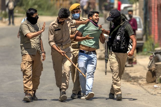 Policemen detain a minority Hindus, locally known as Pandits, during a protest march against the killing of Rahul Bhat, also a Pandit, on the outskirts of Srinagar, Indian controlled Kashmir, Friday, May 13, 2022. Hindus in Indian-controlled Kashmir staged protests on Friday a day after assailants shot and killed the government employee from the minority community. It was the first time that Pandits, an estimated 200,000 of whom fled Kashmir after an anti-India rebellion erupted in 1989, simultaneously organized street protests at several places in the Muslim-majority region. (Photo by Dar Yasin/AP Photo)