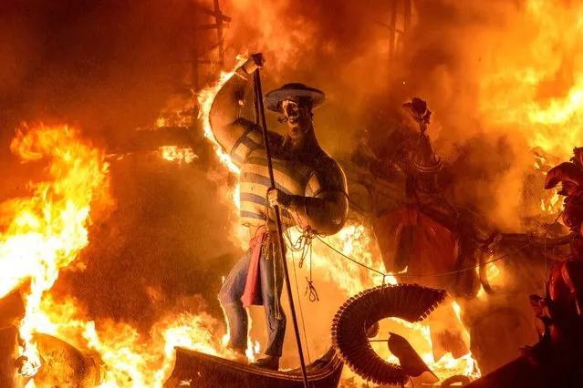 A falla burns during the traditional Fallas festival in Valencia, Spain, Sunday, September 5, 2021. After the suspension of the 2020 Fallas and the postponement of those of 2021 because of the coronavirus pandemic. Valencia celebrates this week its traditional fallas with restrictions and security measures to avoid new contagions. Fallas are gigantic structures made of cardboard portraying current events and personalities in which individual figures or Ninots are placed. (Photo by Alberto Saiz/AP Photo)