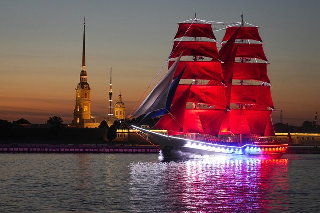 A brig with scarlet sails floats on the Neva River during a rehearsal for the Scarlet Sails festivities marking school graduation in St. Petersburg, Russia, early Tuesday, June 13, 2023. (Photo by Dmitri Lovetsky/AP Photo)